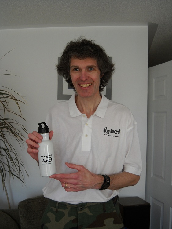 An NCF volunteer shows off the NCF golf shirt and water bottle