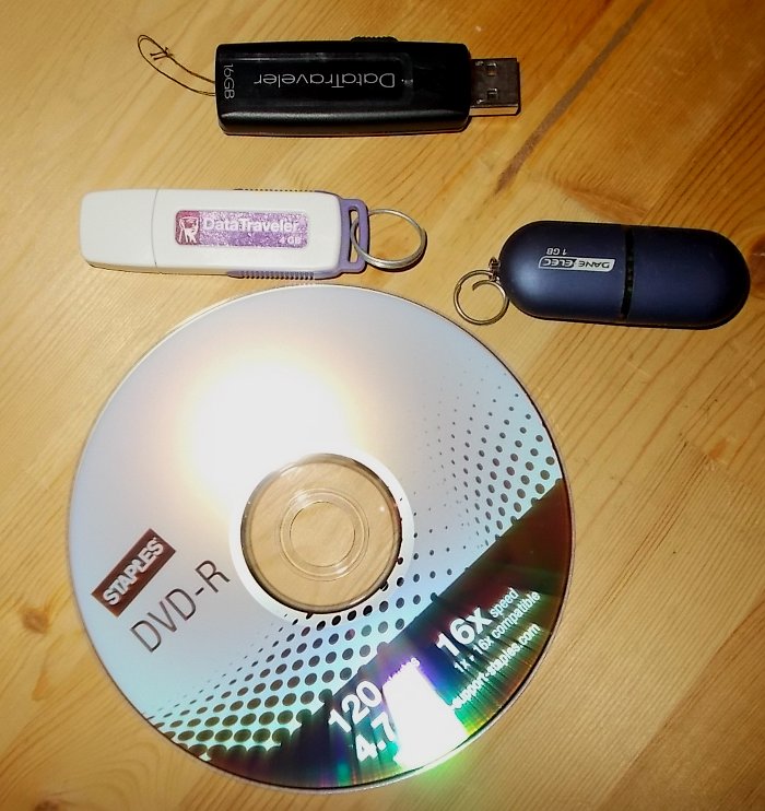 A sample of some methods of backing up your files: a DVD and three USB mass-storage devices ("Thumb drives").